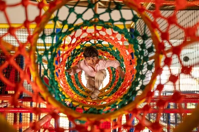 Saudi Boy Playing in Colorful Rope Mesh Tunnel