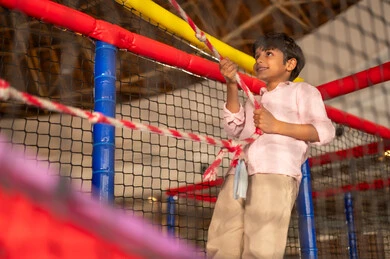Saudi Boy Playing on Rope Course in Indoor Playground