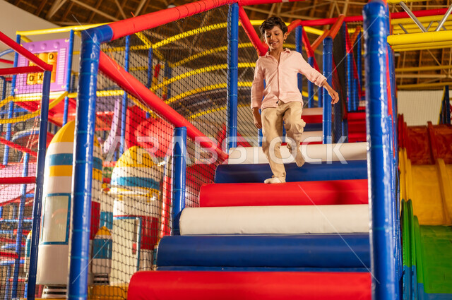 Saudi Boy Running on Stairs in Indoor Play Area
