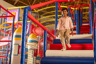 Saudi Boy Walking Down Indoor Playground Stairs