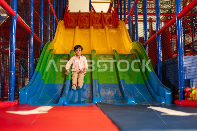 Saudi Boy Sliding Down Indoor Playground Slide
