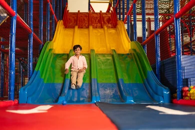 Saudi Boy Sliding Down Indoor Playground Slide