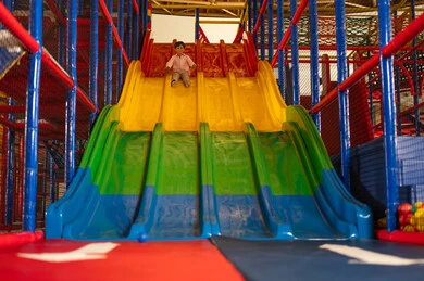 طفل عربي يلعب في منطقة ألعاب داخلية ملونة