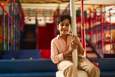 Saudi Boy Smiling in Indoor Playground Setting
