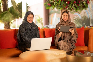 Arab Women in Abayas Using Laptop and Tablet Outdoors