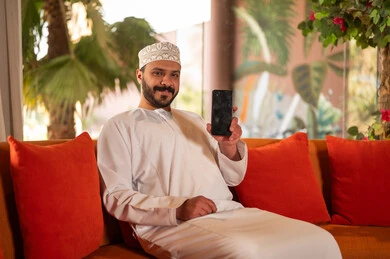 Omani Man Holding Smartphone in Traditional Dress