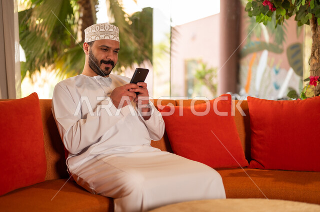 Omani Man Using Smartphone in Traditional Clothing