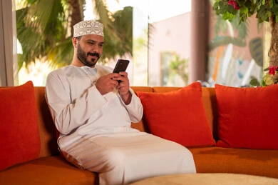 Omani Man Using Smartphone in Traditional Clothing