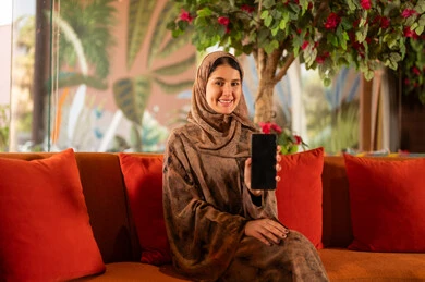 Saudi Woman Holding Smartphone with Blank Screen