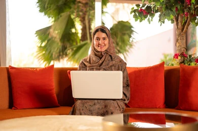 Saudi Woman Using Laptop on Outdoor Lounge Terrace Sofa