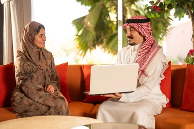 Saudi Man and Woman with Laptop in Traditional Dress