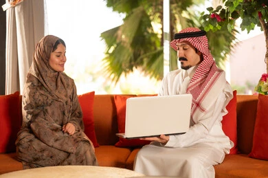 Saudi Couple Using Laptop for Business Discussion