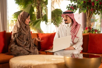 زوجان سعوديان يجريان محادثة عمل باستخدام الكمبيوتر
