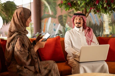 Saudi Man and Woman Using Laptop and Tablet Indoors