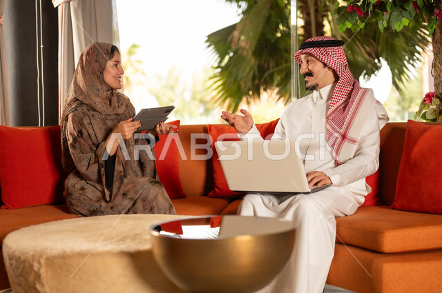Saudi Man and Woman Working with Laptop and Tablet