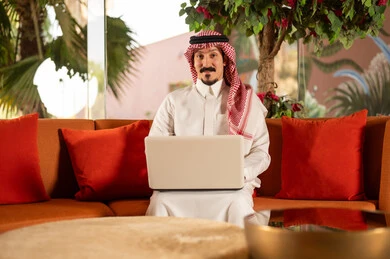 Saudi Businessman Using Laptop in Traditional Thobe