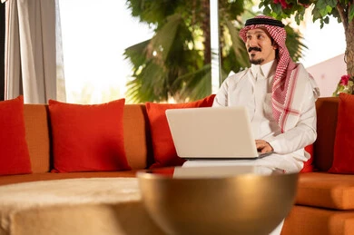 Saudi Businessman Using Laptop on Outdoor Sofa