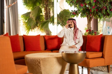Saudi Man in Thobe Talking on Phone in Lounge