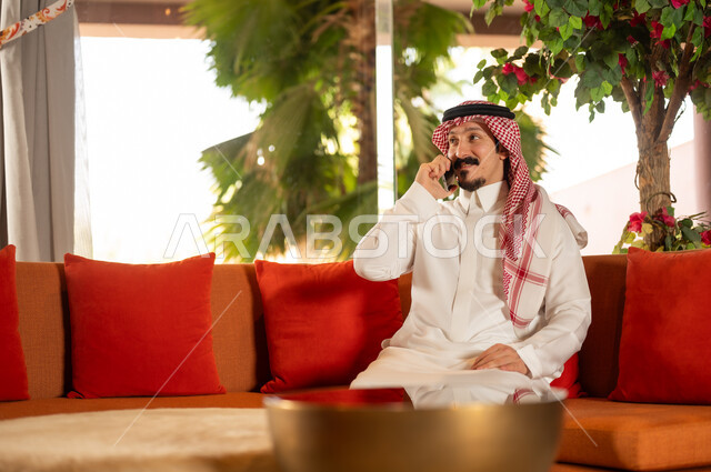 Saudi Man in Traditional Thobe Talking on Mobile Phone