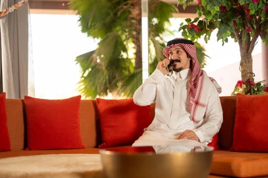 Saudi Man in Traditional Thobe Talking on Mobile Phone