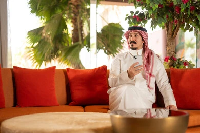 Saudi Man in Traditional Thobe Using Smartphone