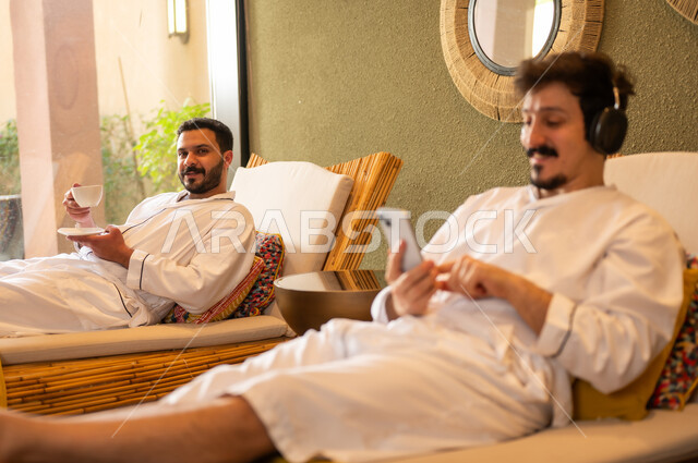 Arab Men in White Robes Relaxing at Spa Resort