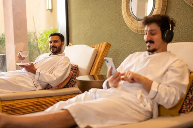 Arab Men in White Robes Relaxing at Spa Resort