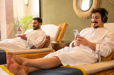 Arab Men Relaxing in Spa with Smartphone and Coffee