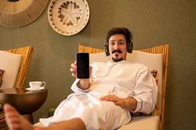 Saudi Man in Bathrobe Using Smartphone at Spa