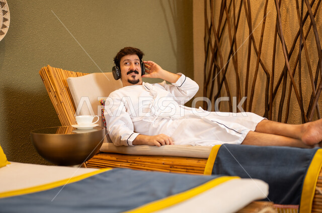 Arab Man Relaxing in Spa with Headphones and Bathrobe