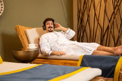 Arab Man Relaxing in Spa with Headphones and Bathrobe