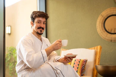 Saudi Man in White Bathrobe Drinking Coffee at Spa
