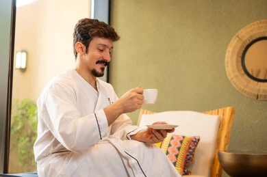 Saudi Man in White Bathrobe Drinking Coffee at Spa