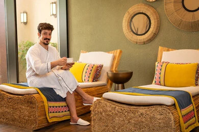 رجل سعودي برداء الحمام يسترخي في سبا داخلي