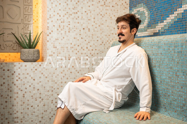رجل سعودي يرتدي رداء حمام في سبا فاخر