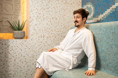 رجل سعودي يرتدي رداء حمام في سبا فاخر