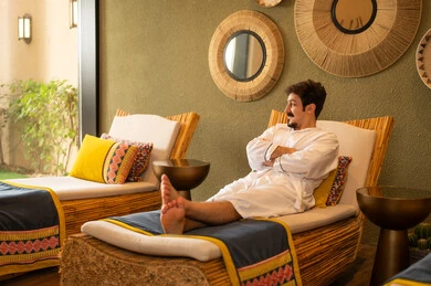 رجل عربي يسترخي في منتجع صحي برداء حمام أبيض