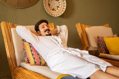 رجل سعودي برداء حمام أبيض يسترخي في منتجع صحي