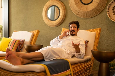 Arab Man in Bathrobe Talking on Phone in Spa