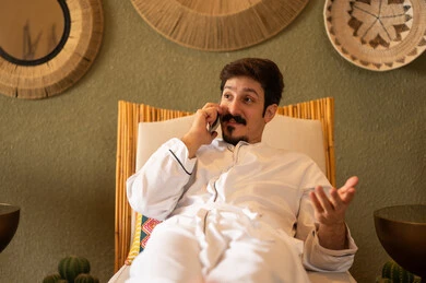 Saudi Man in Traditional Thobe Talking on Smartphone