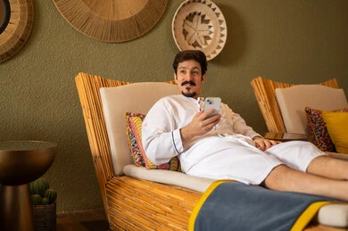 Saudi Man Relaxing in Traditional Spa with Smartphone