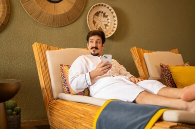 رجل سعودي بالثوب الأبيض يستخدم الجوال في سبا رجل سعودي بالثوب الأبيض يستخدم الجوال في سبا