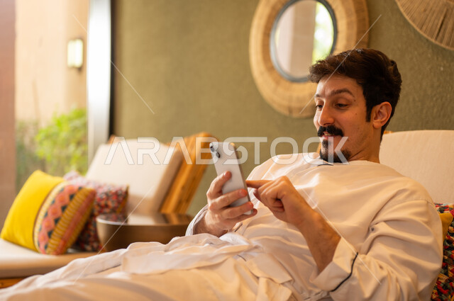 Saudi Man in Bathrobe Using Smartphone in Spa