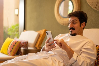 Saudi Man in Bathrobe Using Smartphone in Spa