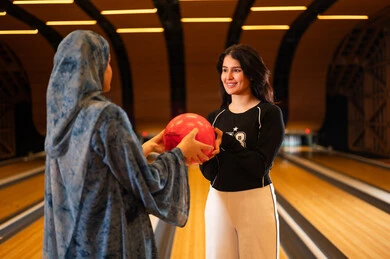 Arab Women Playing Bowling in Indoor Sports Alley