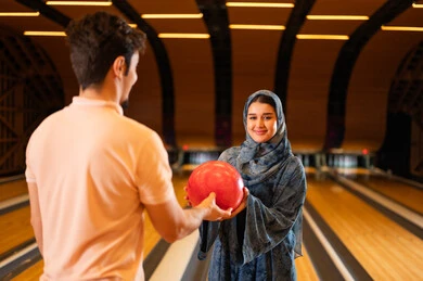 Saudi Couple Playing Bowling in Indoor Entertainment Center