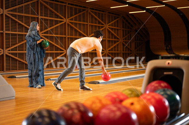 Arab Man and Woman Bowling in Indoor Alley
