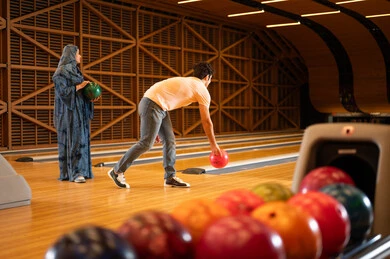 Arab Man and Woman Bowling in Indoor Alley