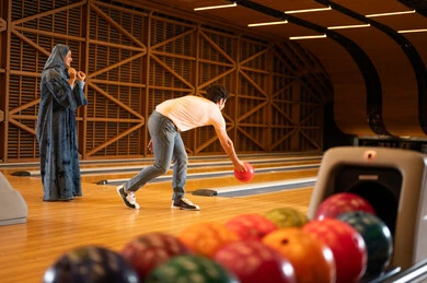 Saudi Couple Playing Bowling in Indoor Recreation Center