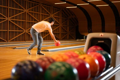 Saudi Man Playing Bowling in Indoor Recreation Center